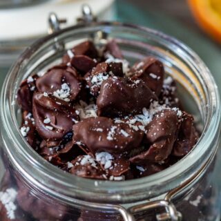 Chocolate covered cranberries sprinkled with coconut flakes