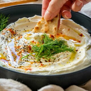 Scooping whipped feta dip with tortilla chips