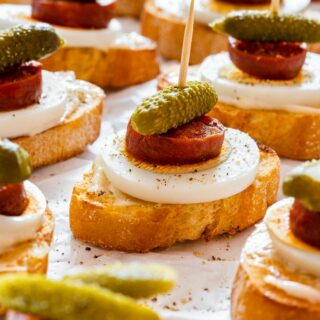 Chorizo crostini with egg and dill pickle