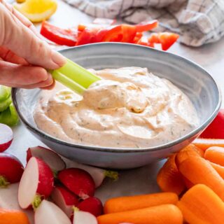 Dipping celery into homemade veggie dip.