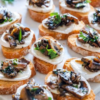 Mushroom crostini with goat cheese, topped with parsley.