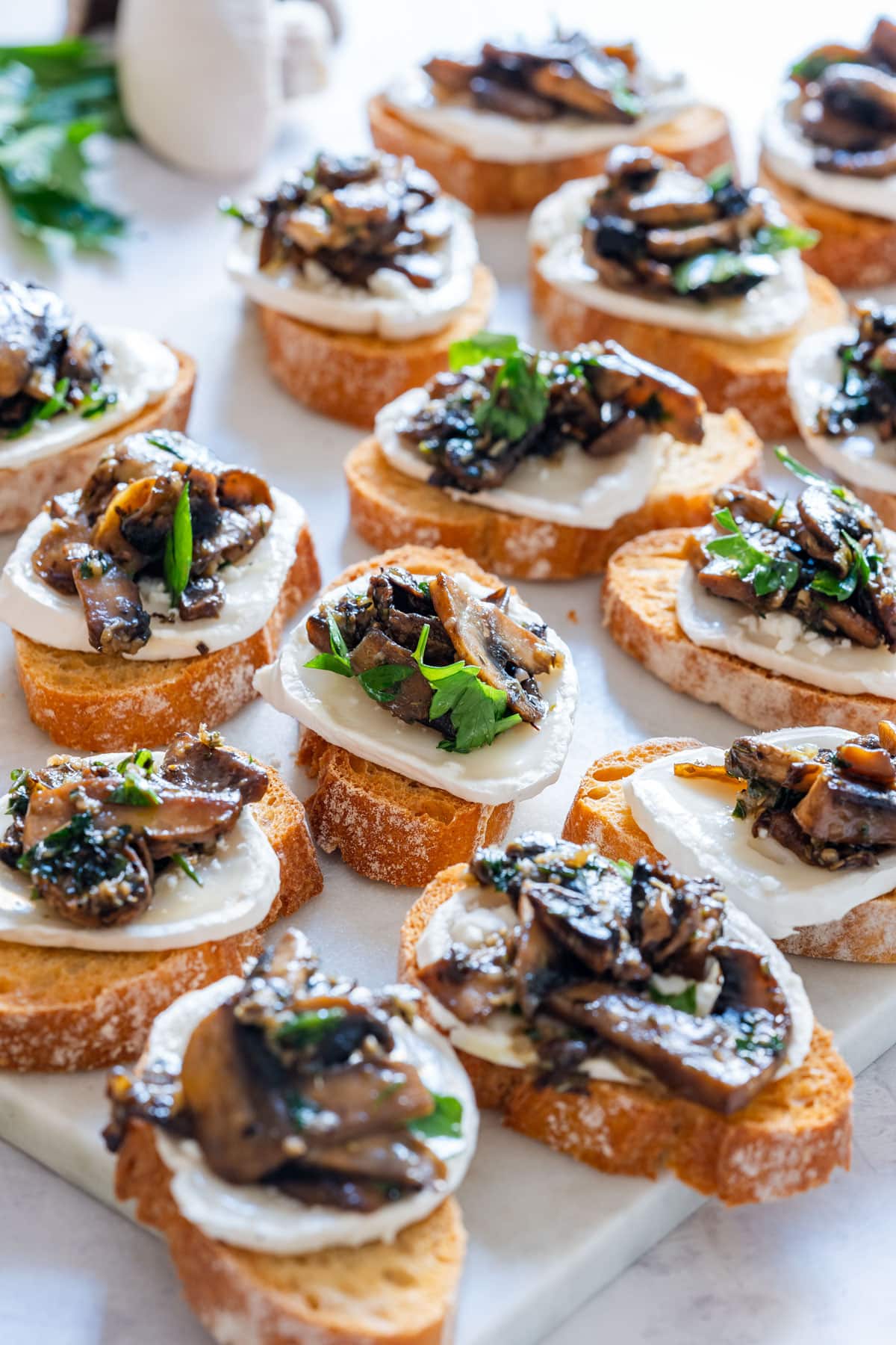Mushroom crostini with goat cheese, topped with parsley.