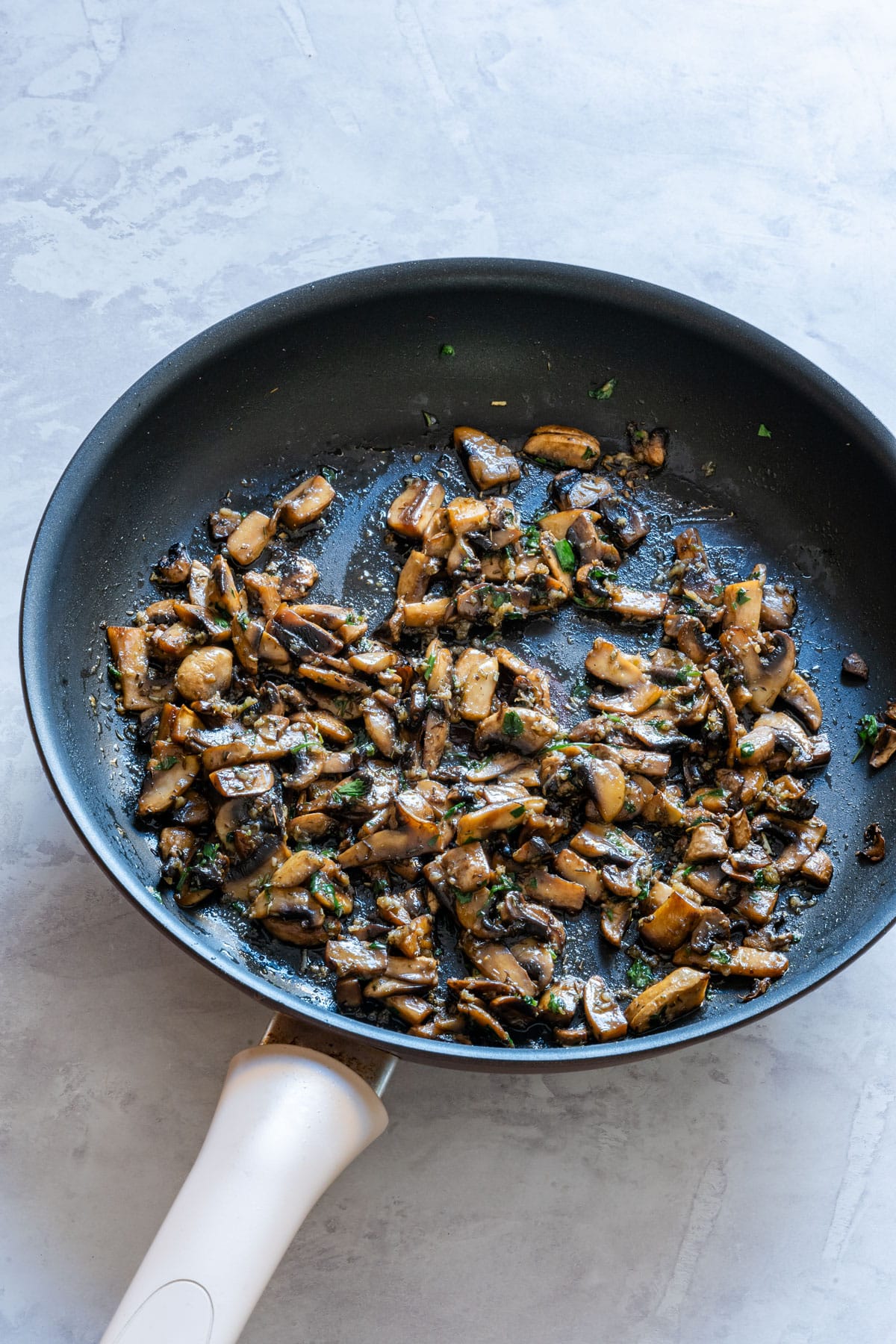Sauteing mushrooms on a frying pan.