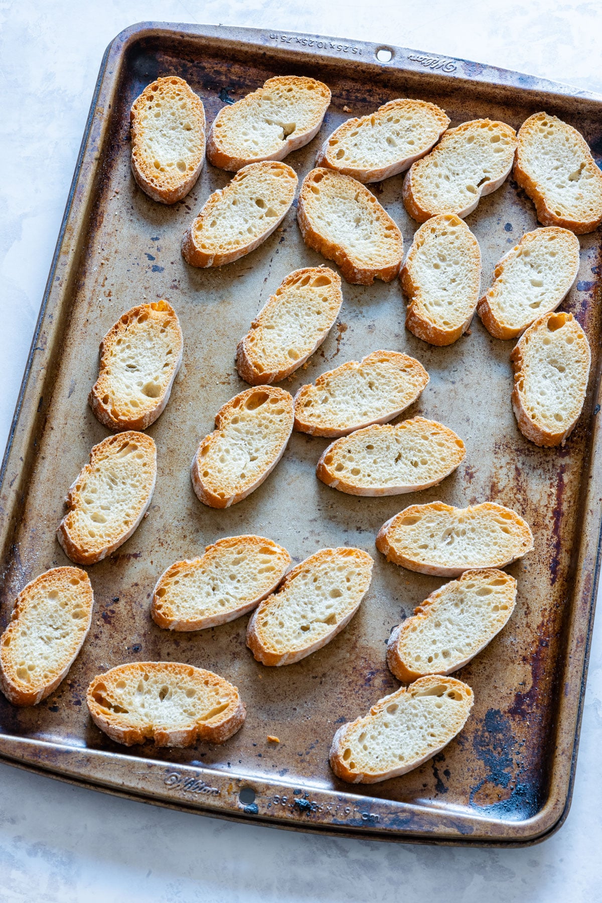 Toasted crostini on a baking tray.