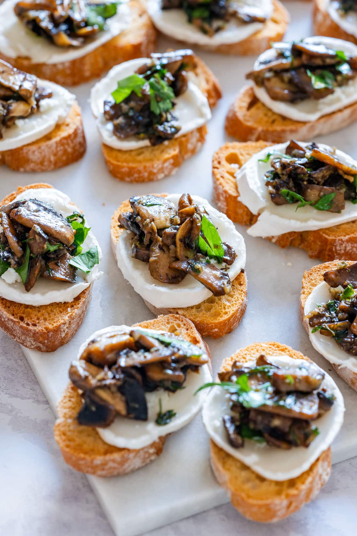 Selection of toasted crostini with goat cheese and mushroom.