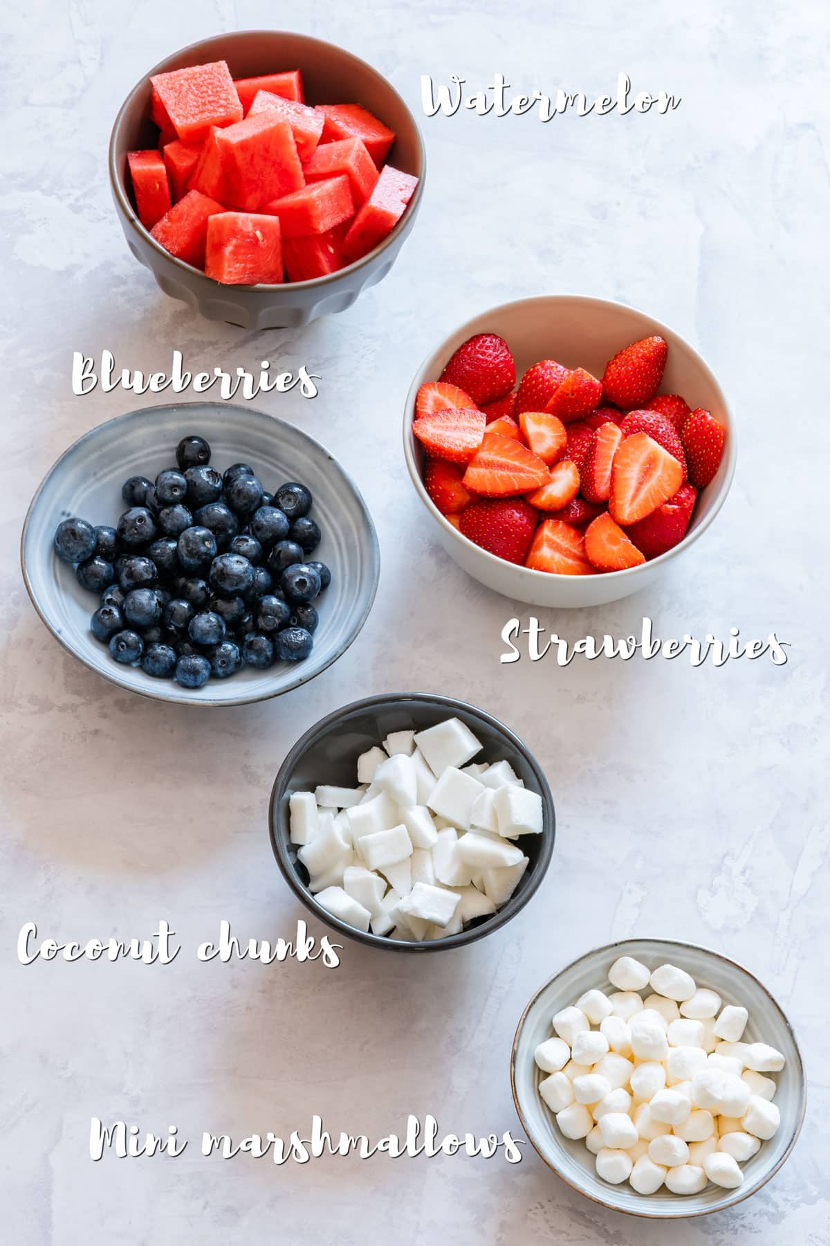 Ingredients for 4th of July fruit platter: strawberries, watermelon, blueberries, coconut chunks and marshmallows.