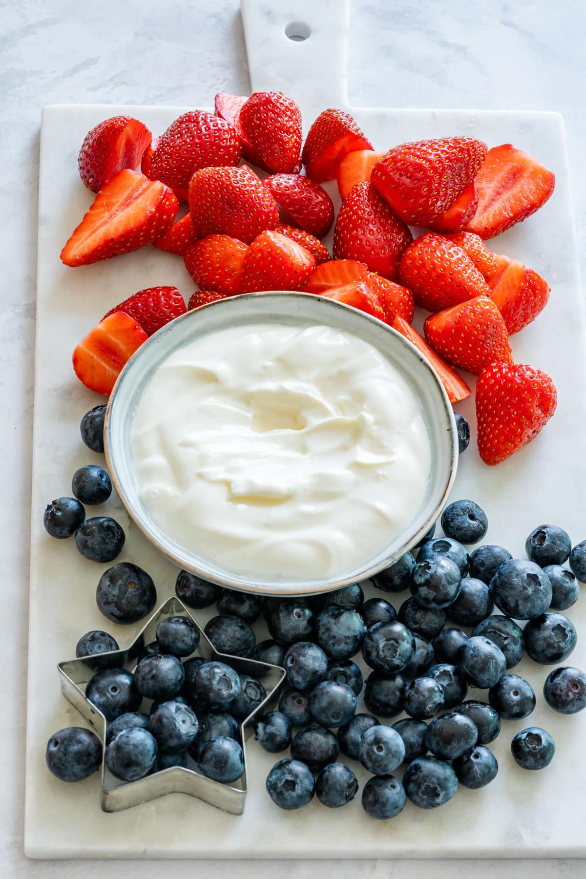 Fruit dip with Greek yogurt and fresh strawberries and blueberries.