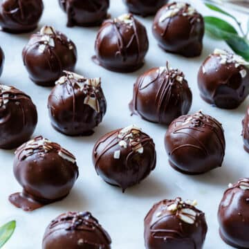 Chocolate peanut butter balls with drizzled chocolate and almond flake toppings.