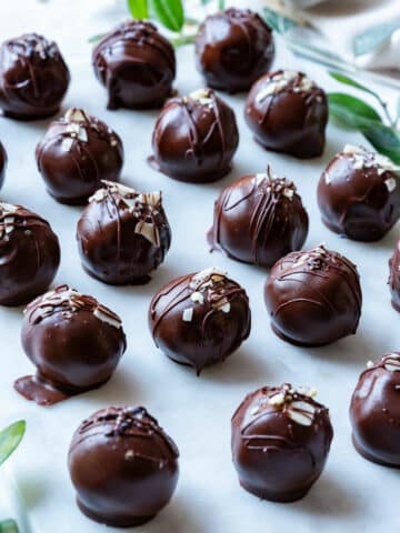 Chocolate peanut butter balls with drizzled chocolate and almond flake toppings.