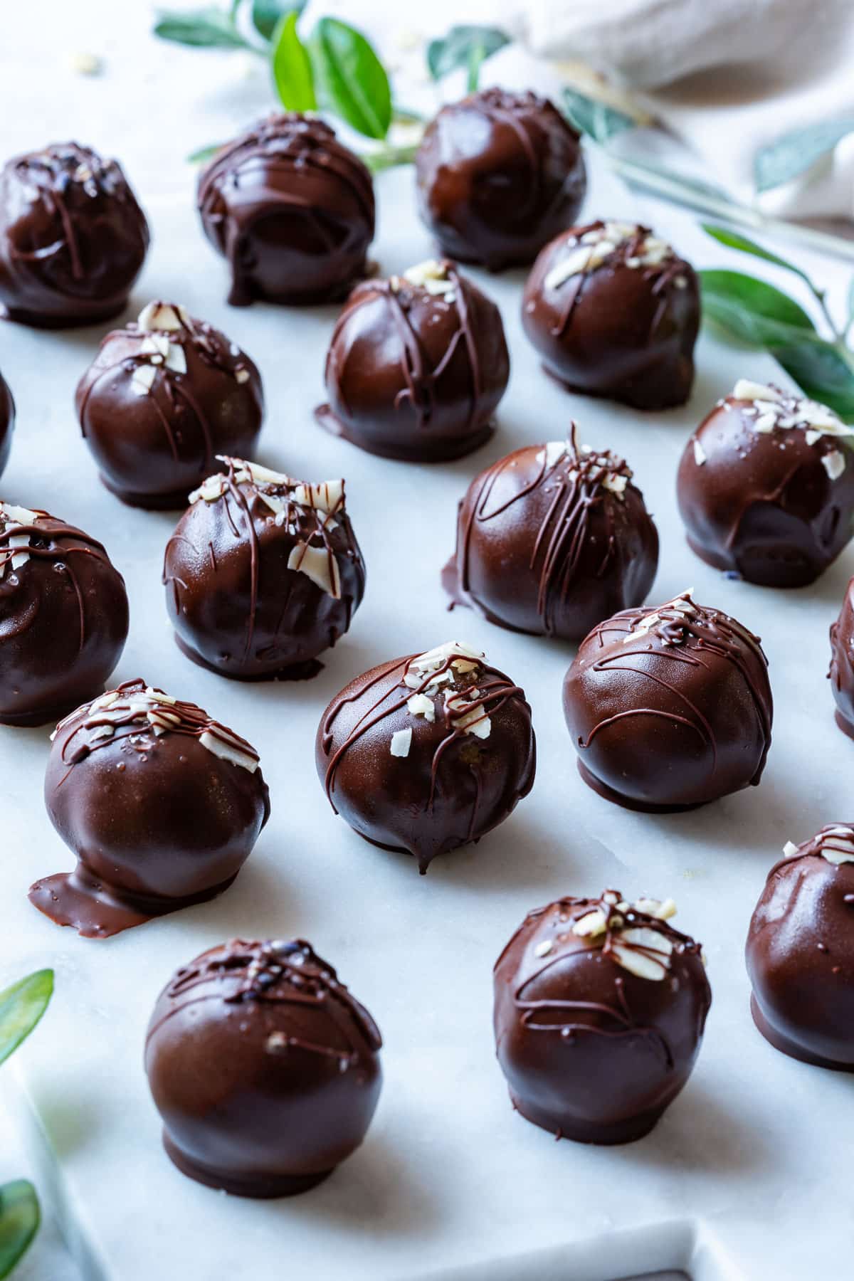 Chocolate peanut butter balls with drizzled chocolate and almond flake toppings.