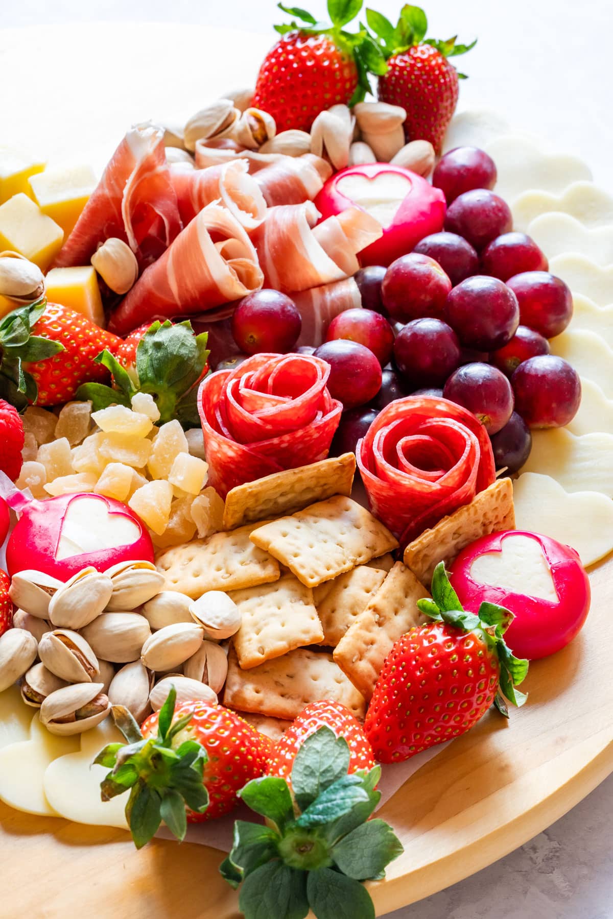 Closeup of the Valentine's Day charcuterie board with various meats and cheese with fruits, crackers and nuts.